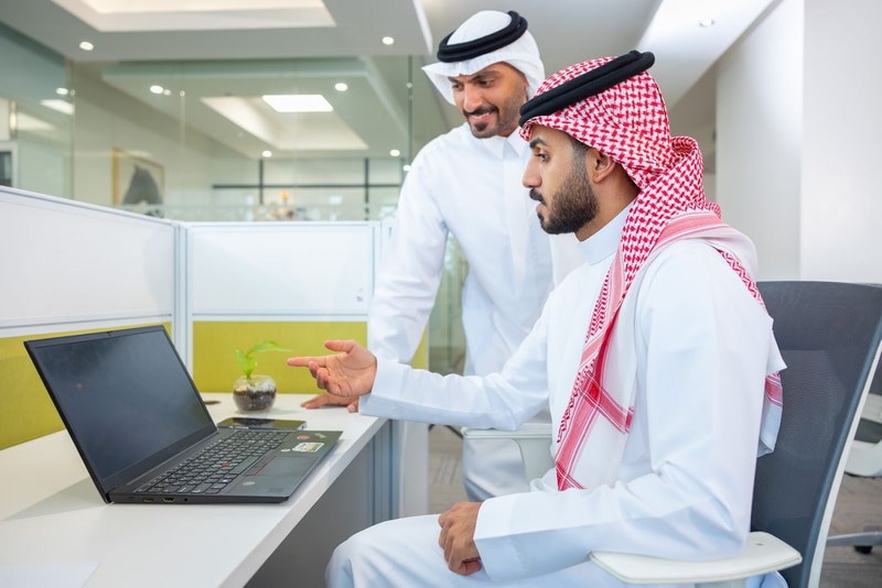 زميلان يعملان معًا على حاسوب محمول