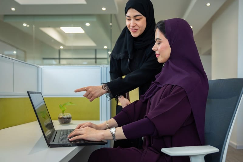 موظفتان تعملان معًا على حاسوب محمول
